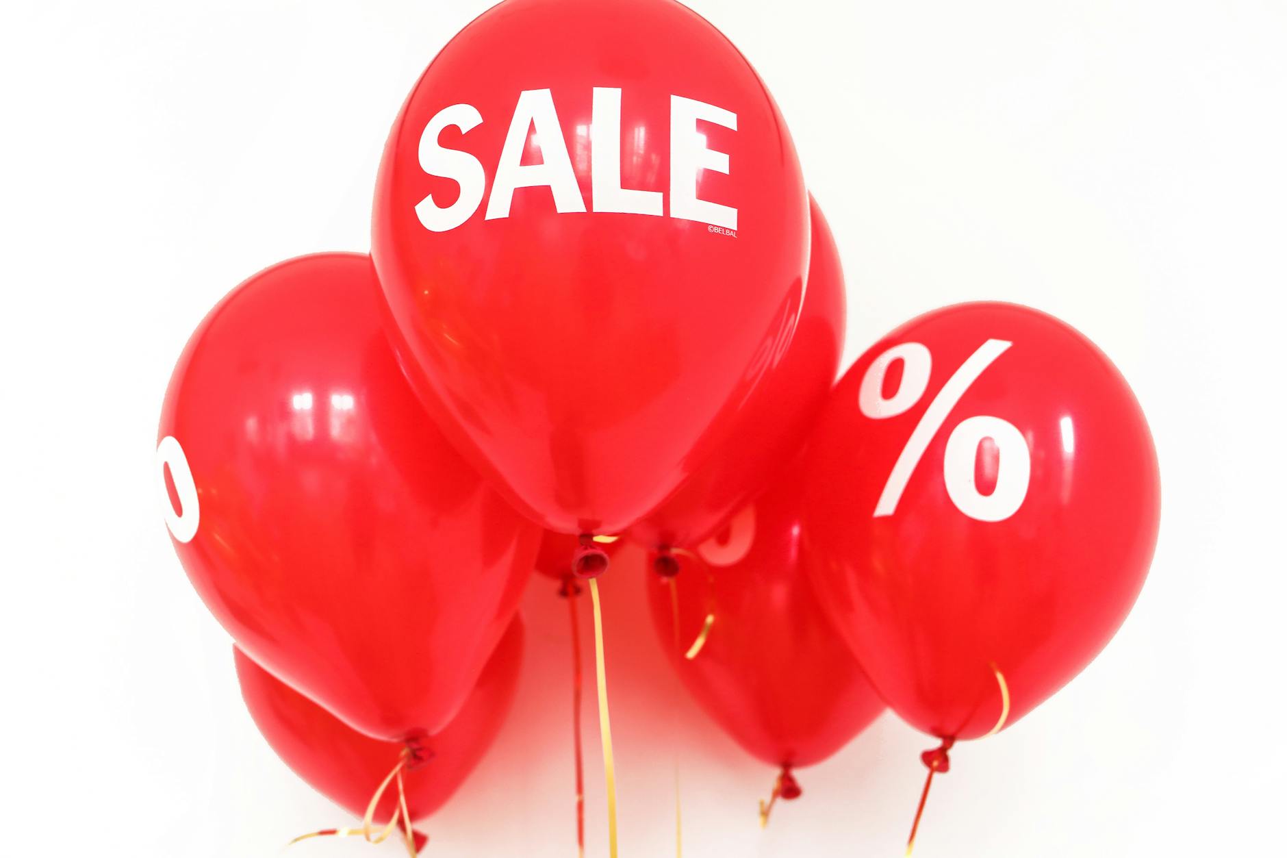 Red balloons with white text that reads 'SALE' and '%', symbolizing discounts and sales promotions.