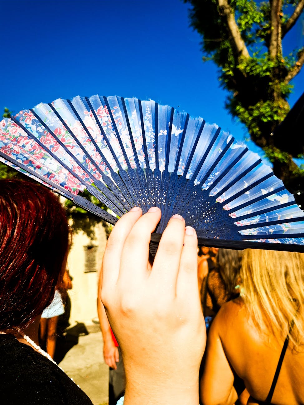 colorful hand fan held at outdoor festival